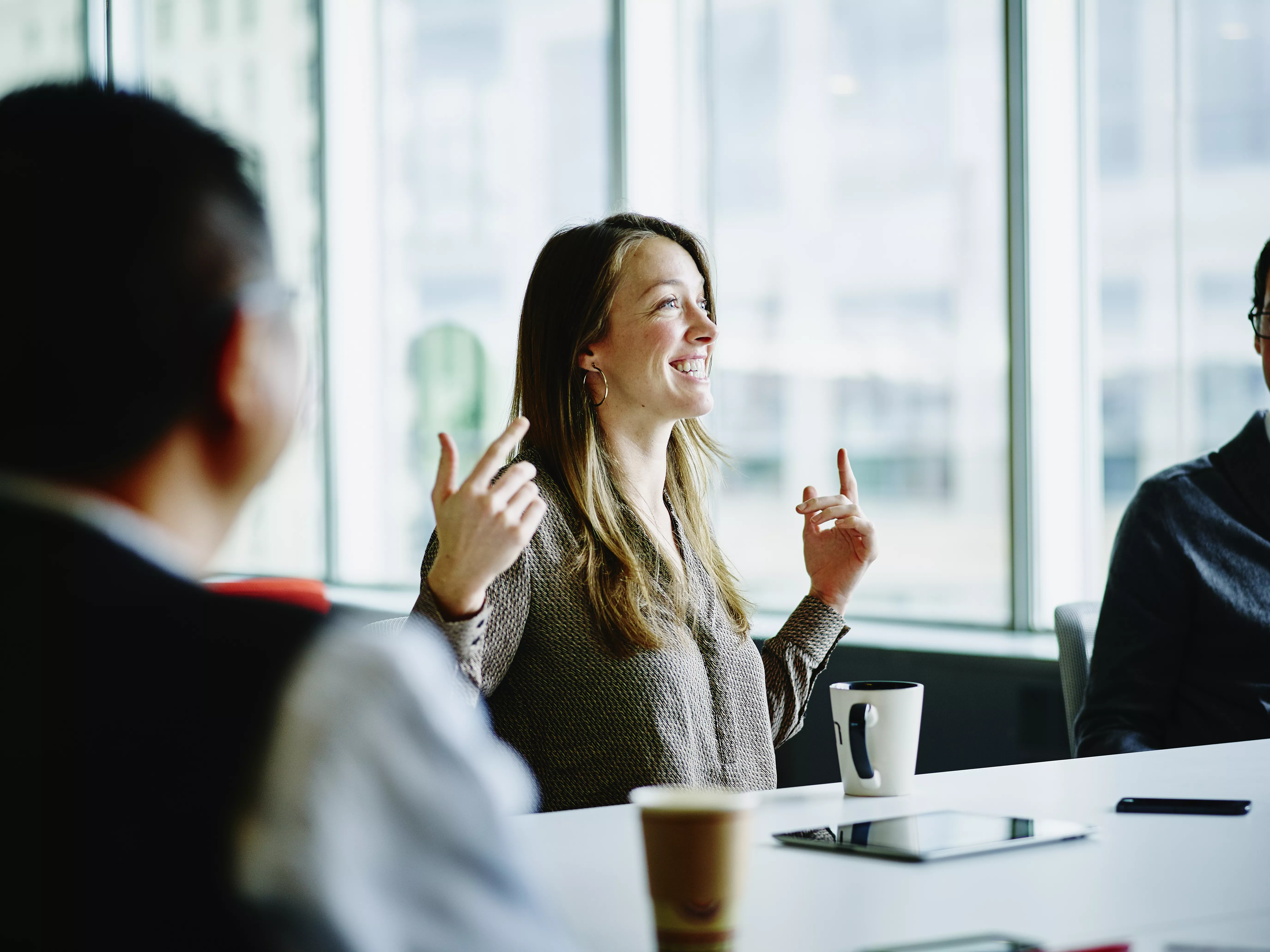 woman smiling and talking in office boardroom